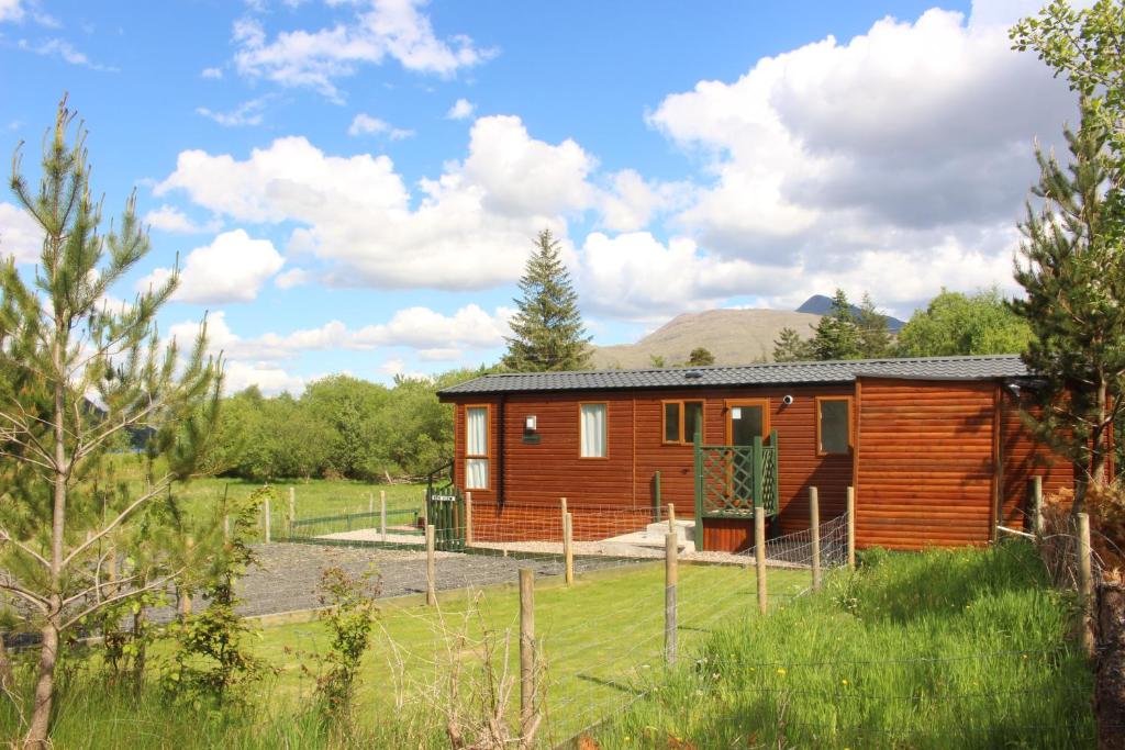 a log cabin in the middle of a field at Ben View in Taynuilt