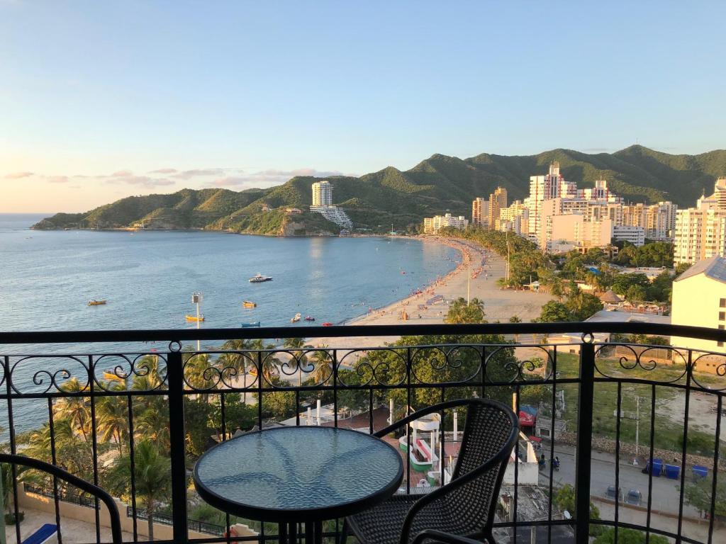 a balcony with a table and chairs and a beach at EDIFICO EL PEÑON DEL RODADERO APTO. 405A in Santa Marta