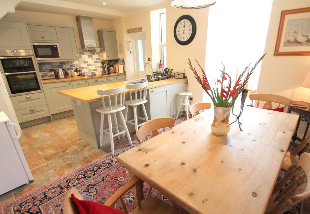 a kitchen with a wooden table with a vase of flowers on it at Pip's Corner in Lynton