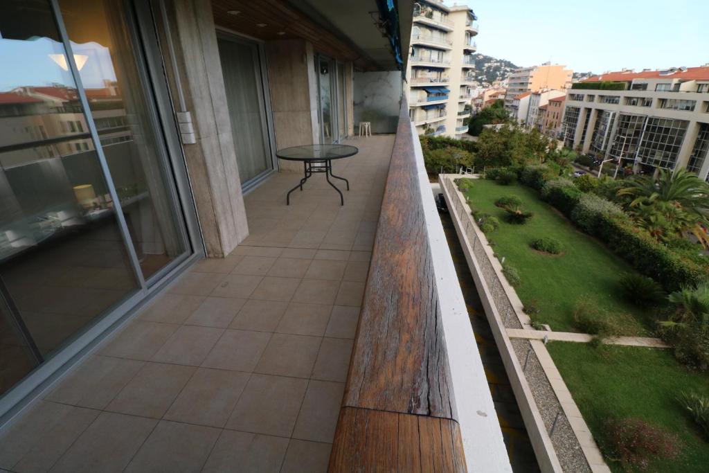 a balcony of a building with a table on it at 2, 3 and 4 bedroom sea view Forville Apartments 5 mins from the Palais in Cannes