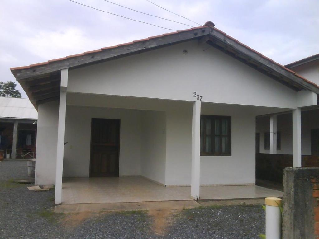 a small white house with a garage at Residência Deolindo in Itapoa