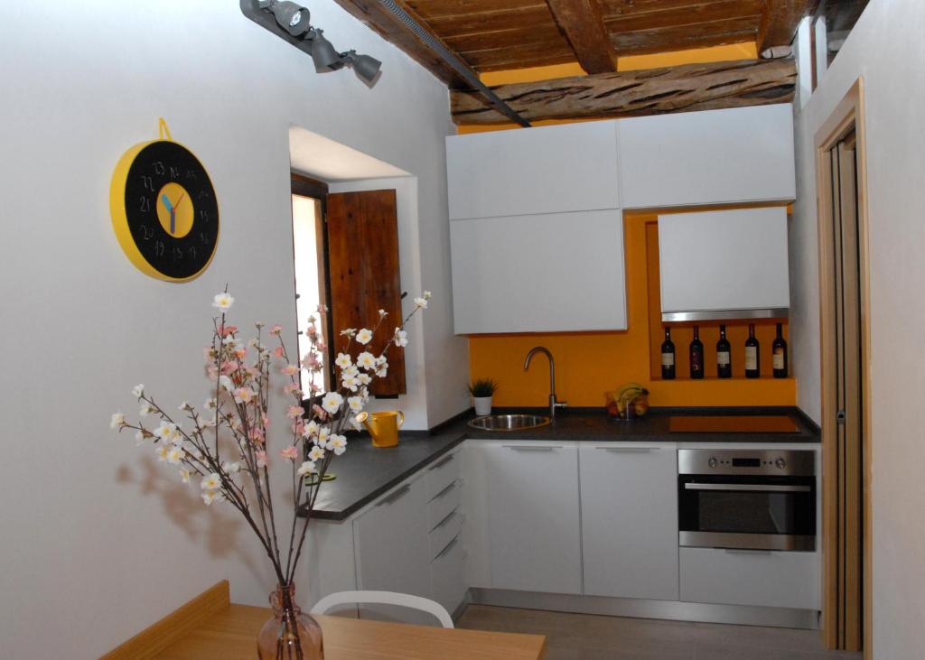 una cucina con armadi bianchi e un vaso con fiori di Antica Dimora I Dragoni a Cagliari