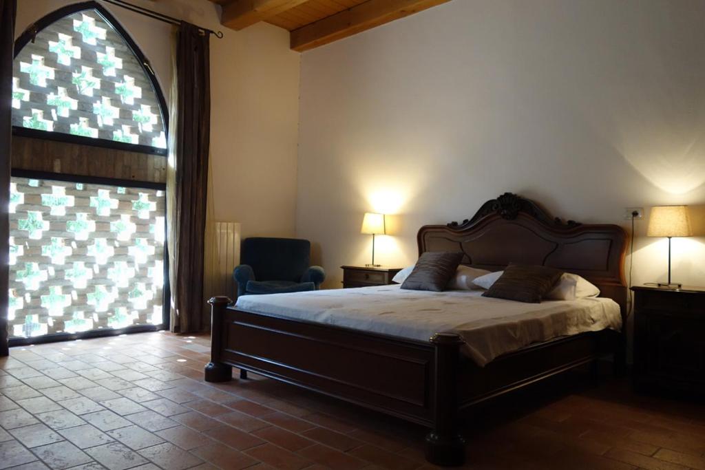 a bedroom with a bed and a large window at Agriturismo Molino Nuovo in Castel San Pietro Terme