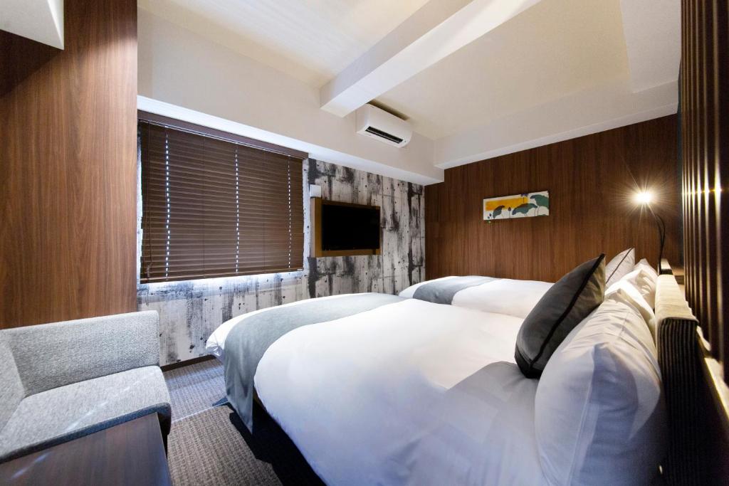 Postel nebo postele na pokoji v ubytování HOTEL HILLARYS Shinsaibashi