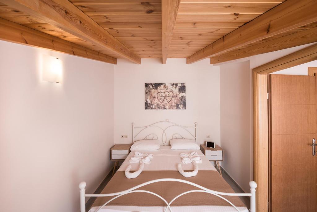 1 dormitorio con cama y techo de madera en Athina Apartments, en Plataniás