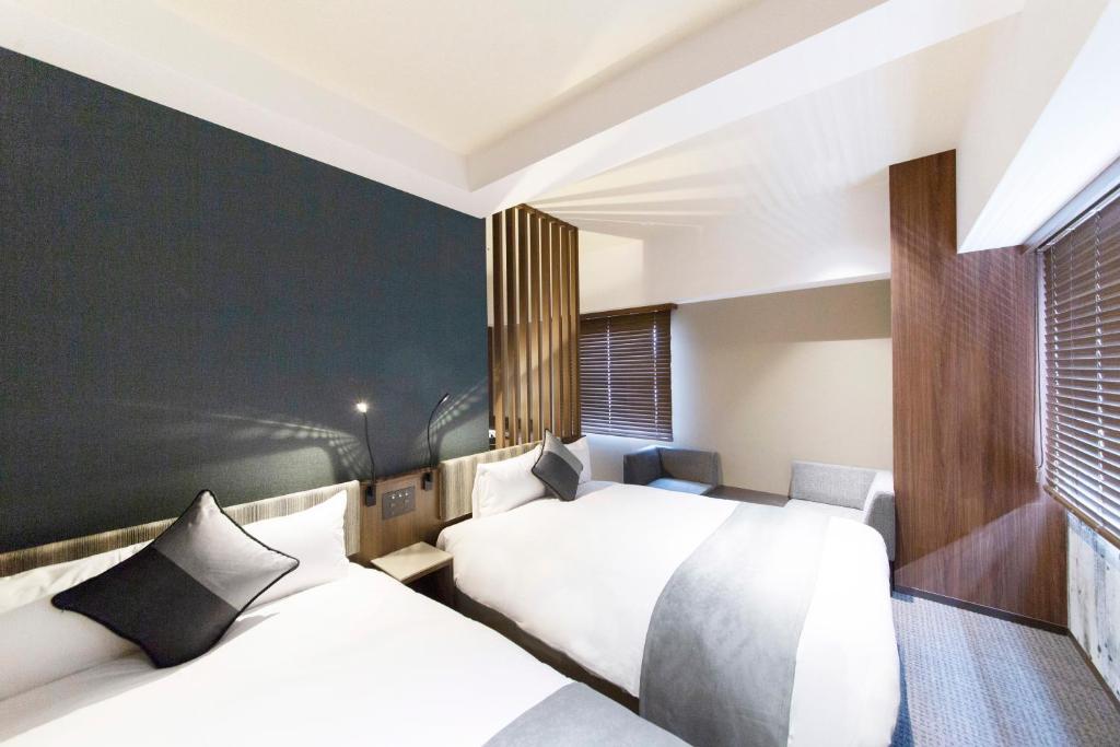 Postel nebo postele na pokoji v ubytování HOTEL HILLARYS Shinsaibashi