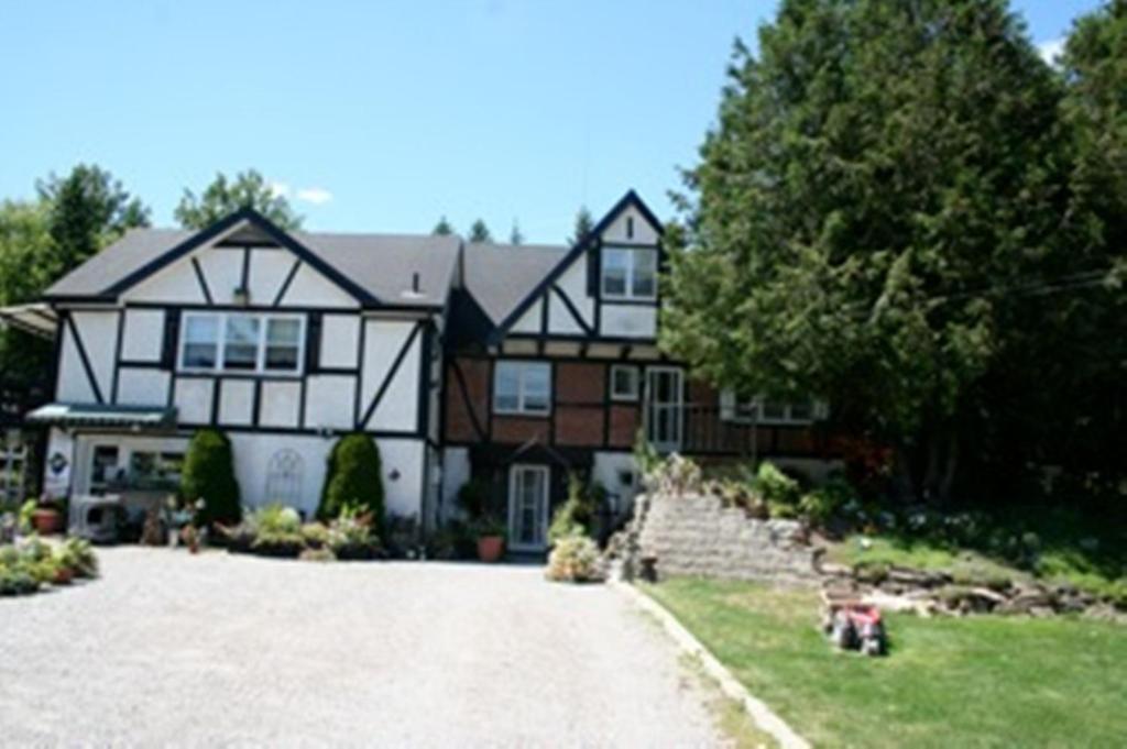 a large black and white house with a driveway at Burley's Executive Garden Suite in Peterborough