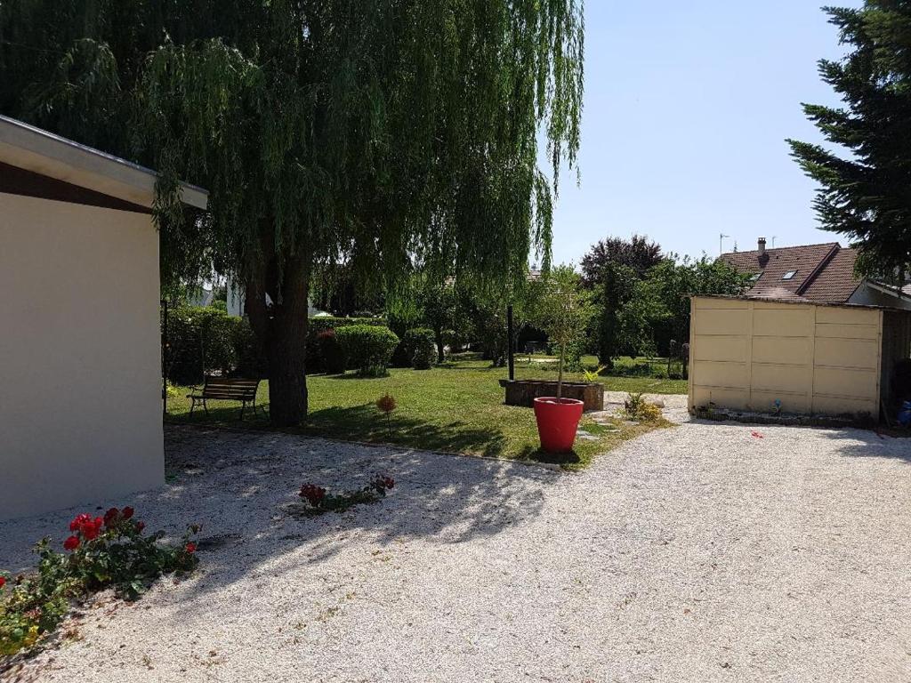 un patio con un gran árbol y un camino de entrada en La Bikok en Billy