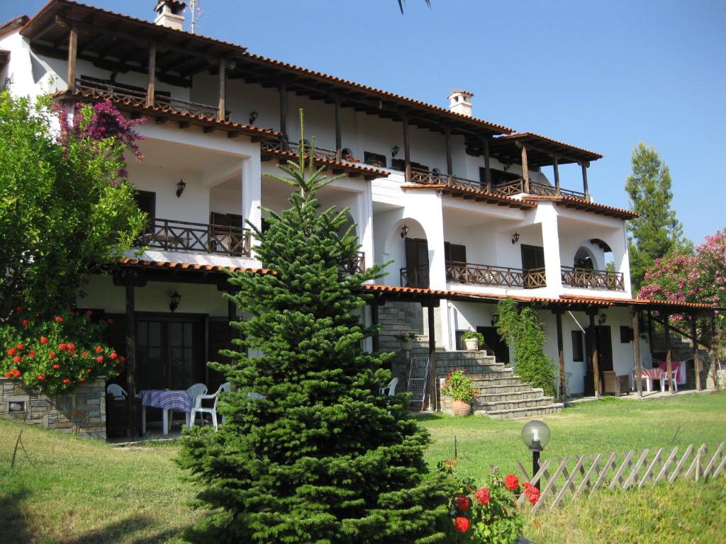 a large house with a christmas tree in front of it at Helios Land in Neos Marmaras