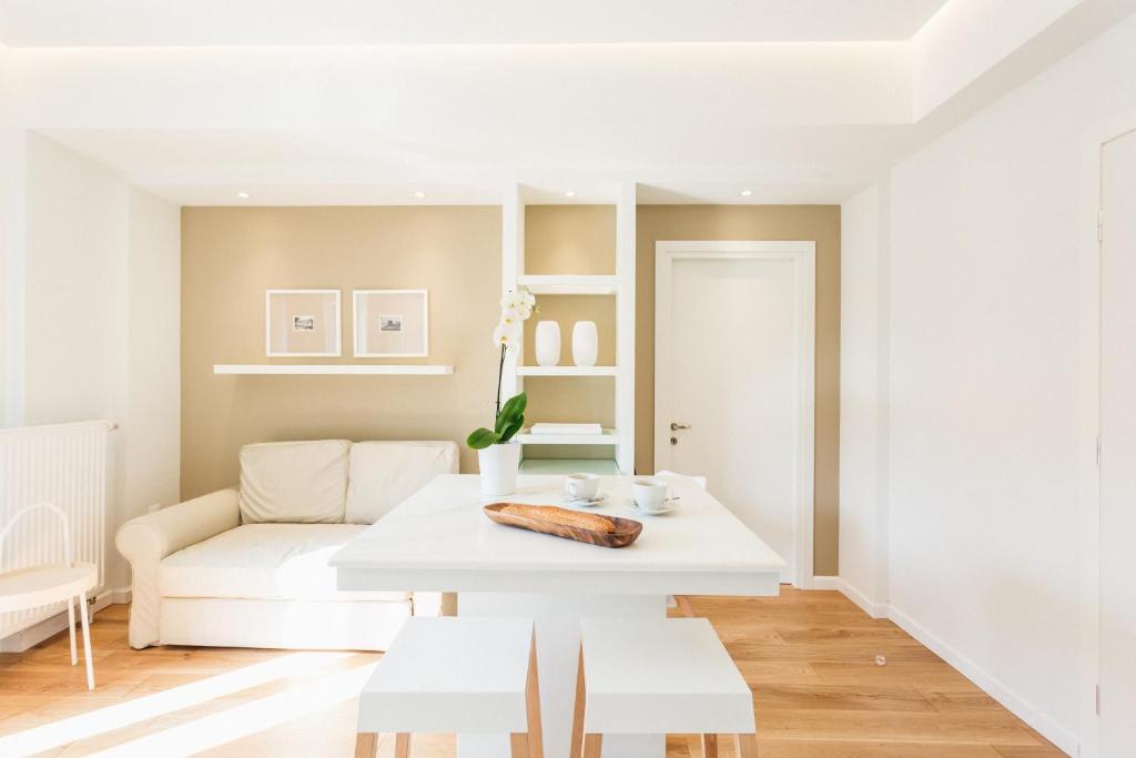 a white living room with a table and a couch at Lori Margariti Sea View Flat in Thessaloniki