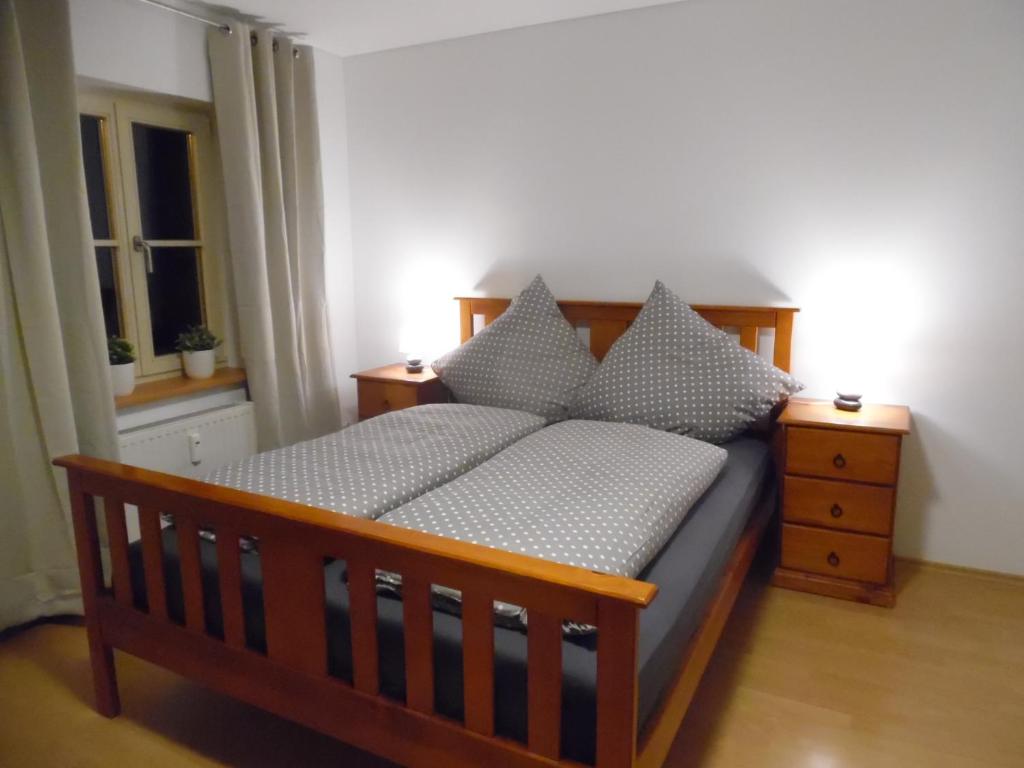 - une chambre avec un lit en bois et des oreillers dans l'établissement Zum Augustiner I, Erfurt Zentrum, à Erfurt