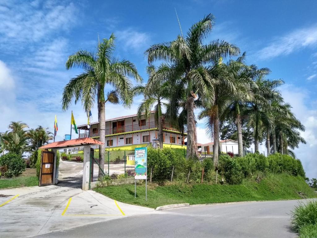 a building with palm trees in front of a street at Paraíso Tropical in Aguadas