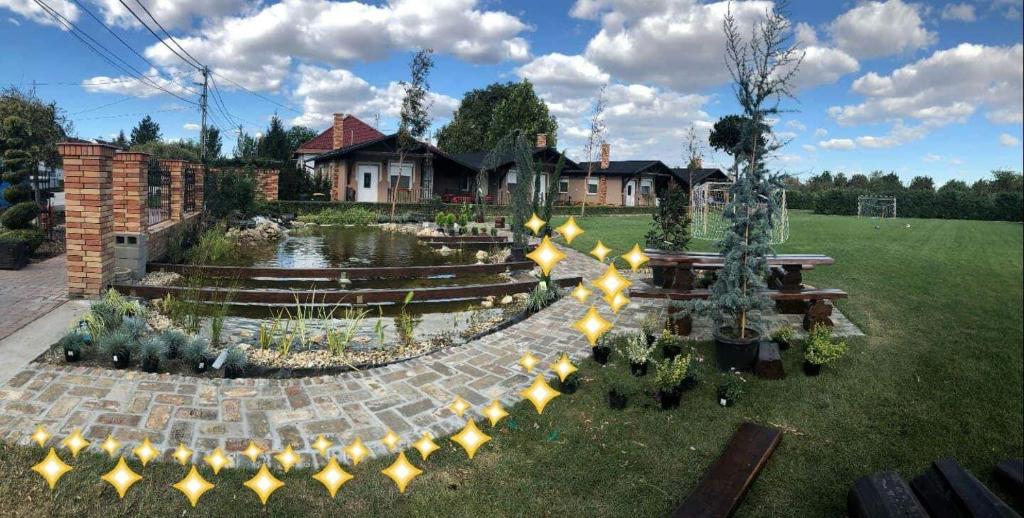 einen Hinterhof mit einem Garten mit Beleuchtung und einem Haus in der Unterkunft Barna Bár Motel&Apartman in Tetélen