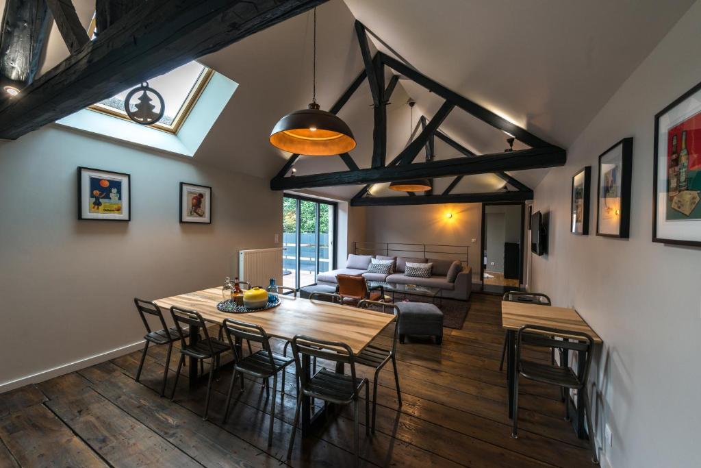 een woonkamer met een tafel en stoelen en een bank bij Gite de la Fée in Beaune