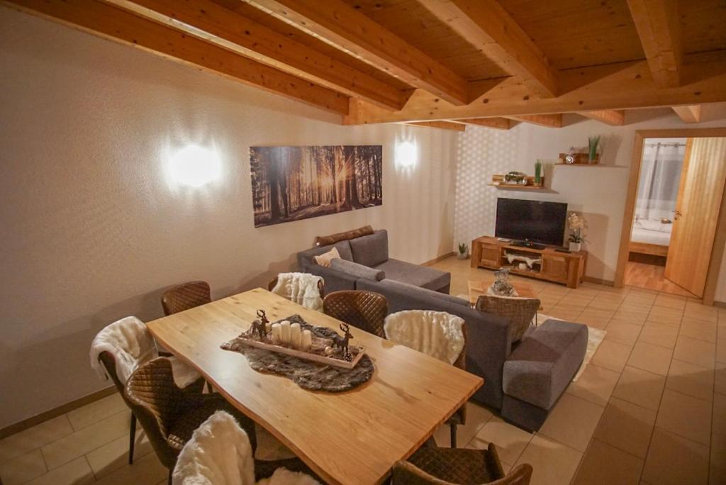 a living room with a table and a couch at Apart Waldblick in Oetz