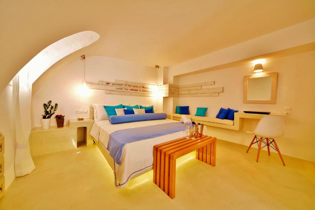 Un dormitorio con una cama grande y una mesa. en Chroma Suites, en Oia