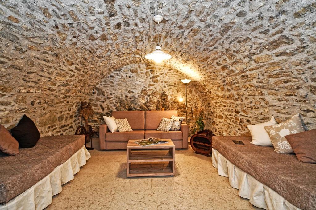 salon z 2 kanapami i kamienną ścianą w obiekcie Villa delle Querce w Tremosine Sul Garda