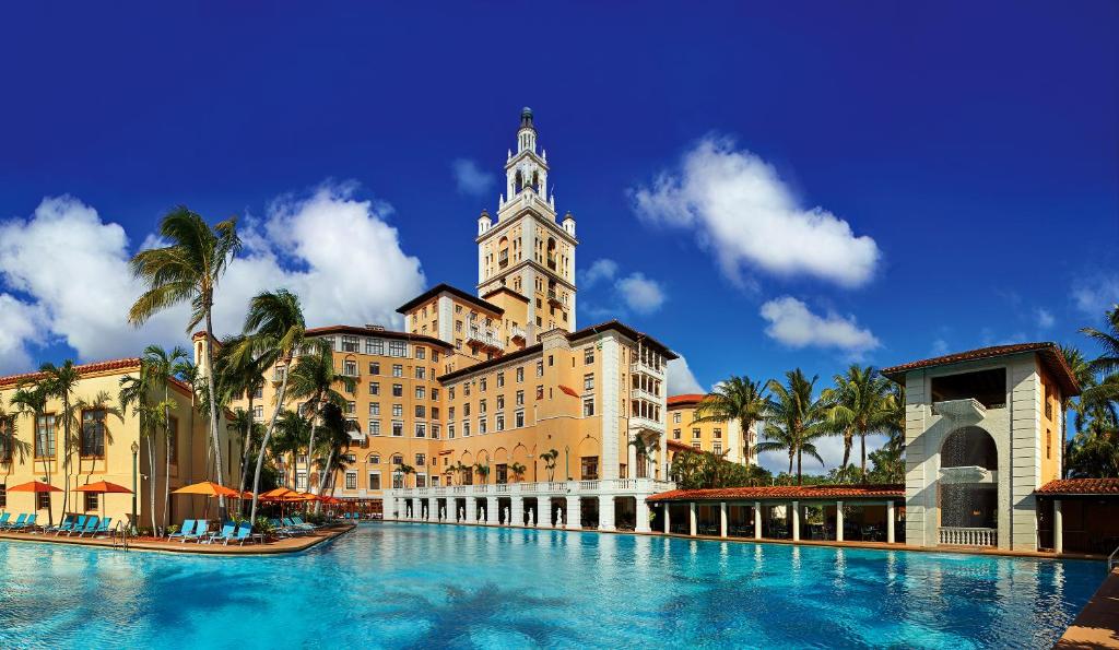 um grande edifício com uma torre do relógio e uma piscina em Biltmore Hotel Miami Coral Gables em Miami