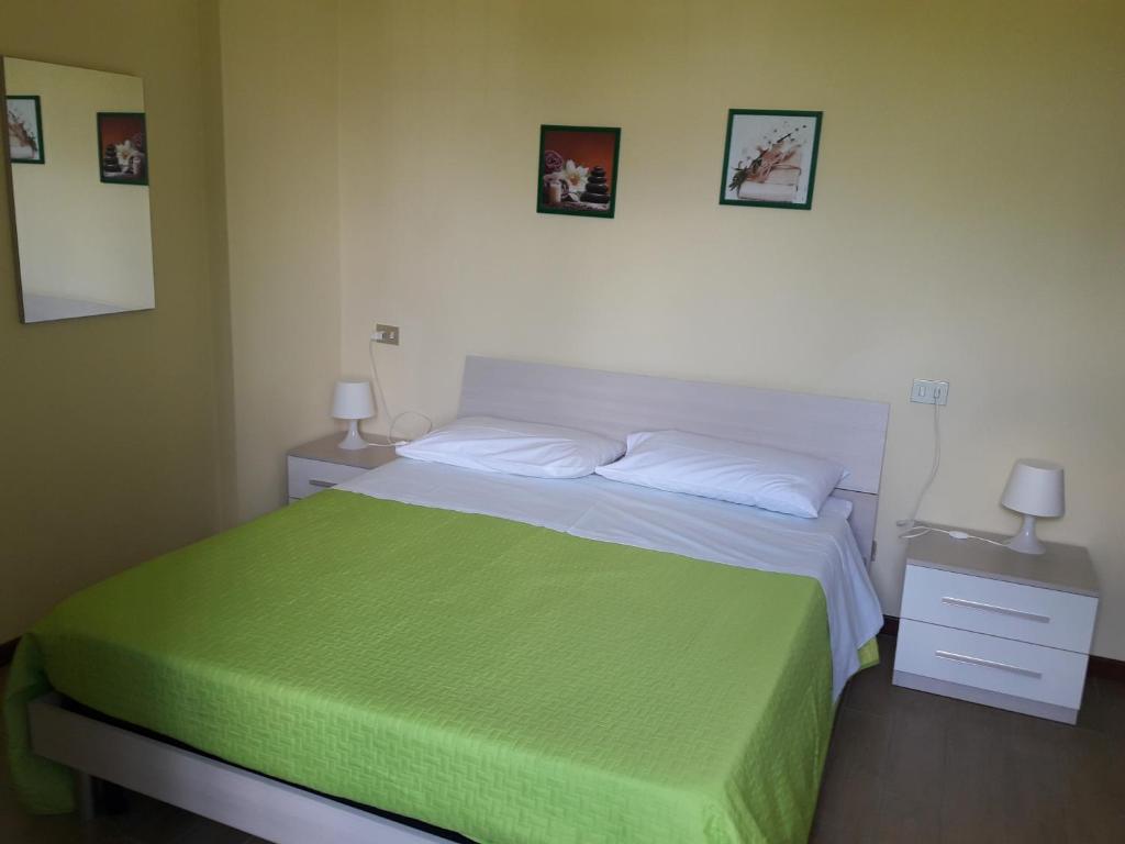 ein Schlafzimmer mit einem Bett mit einer grünen Decke in der Unterkunft La Casa Nel Verde 2 in Bologna