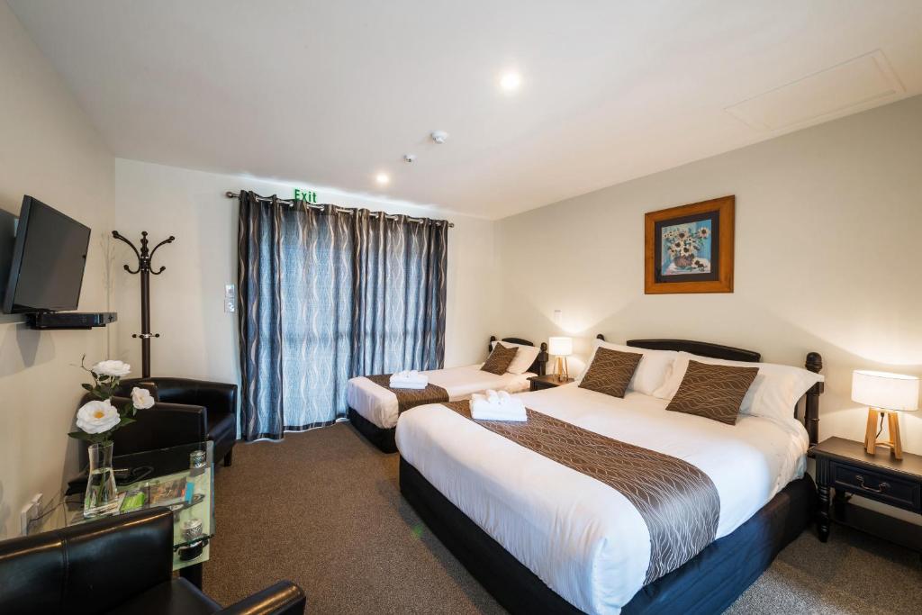 a hotel room with two beds and a television at 123 Motel in Christchurch