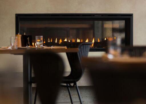 a table with chairs and a fireplace in a restaurant at Shoreline Hotel in Hobart
