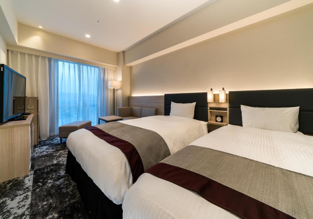 Ліжко або ліжка в номері Daiwa Roynet Hotel Himeji