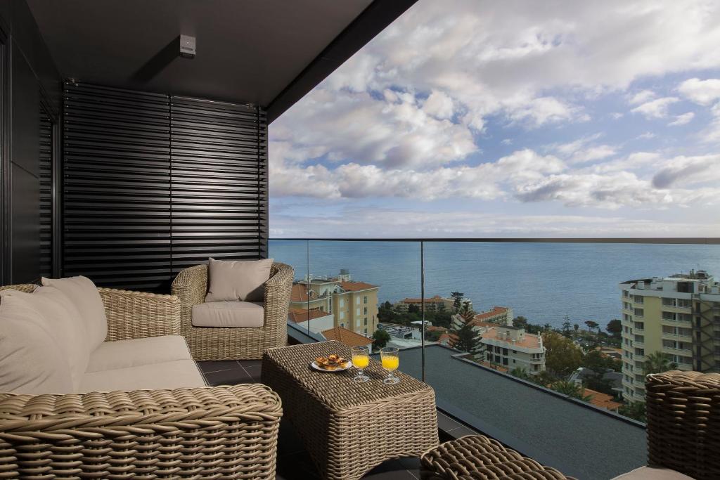 Un balcón con sillas y vista al mar. en Angel´s Paradise Luxury and Sophistication, en Funchal