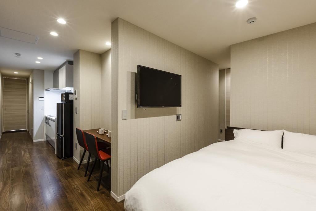 a hotel room with a bed and a desk and a television at Kyo no yado en in Kyoto