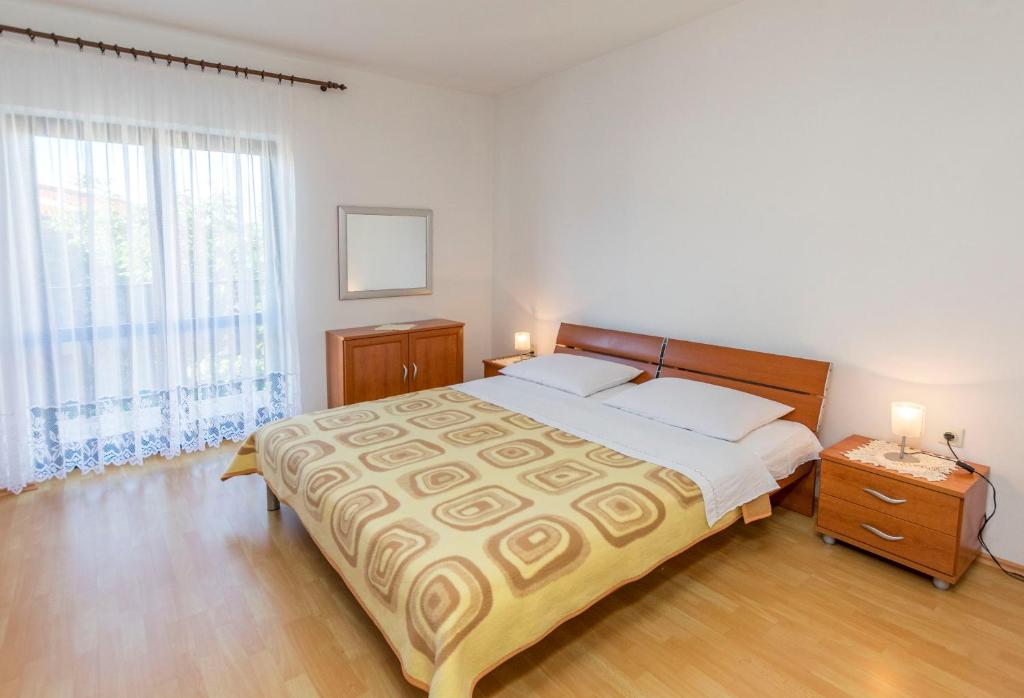 1 dormitorio con cama grande y ventana grande en Apartments Matejka I, en Primošten
