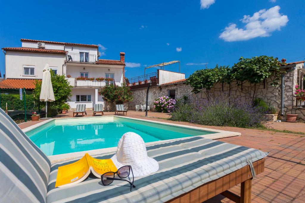 a swimming pool with two chairs and a pair of glasses at Casa Kujici in Krnica
