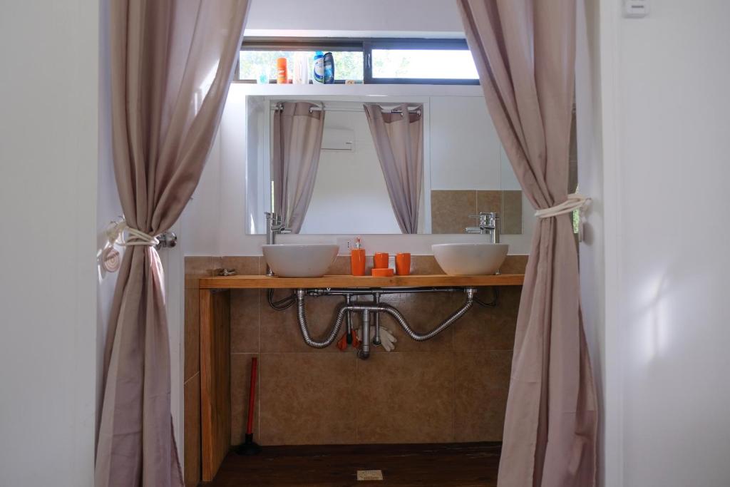 La salle de bains est pourvue de 2 lavabos et d'un miroir. dans l'établissement Las cabañas de macarena, à Punta del Este