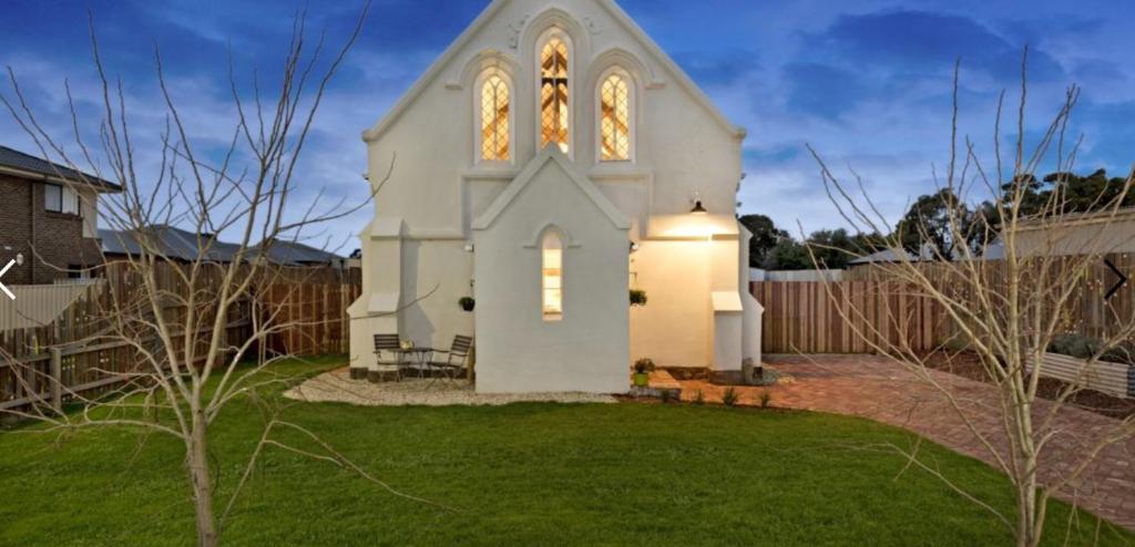 a small white church in a yard at St James Converted Church in Miners Rest