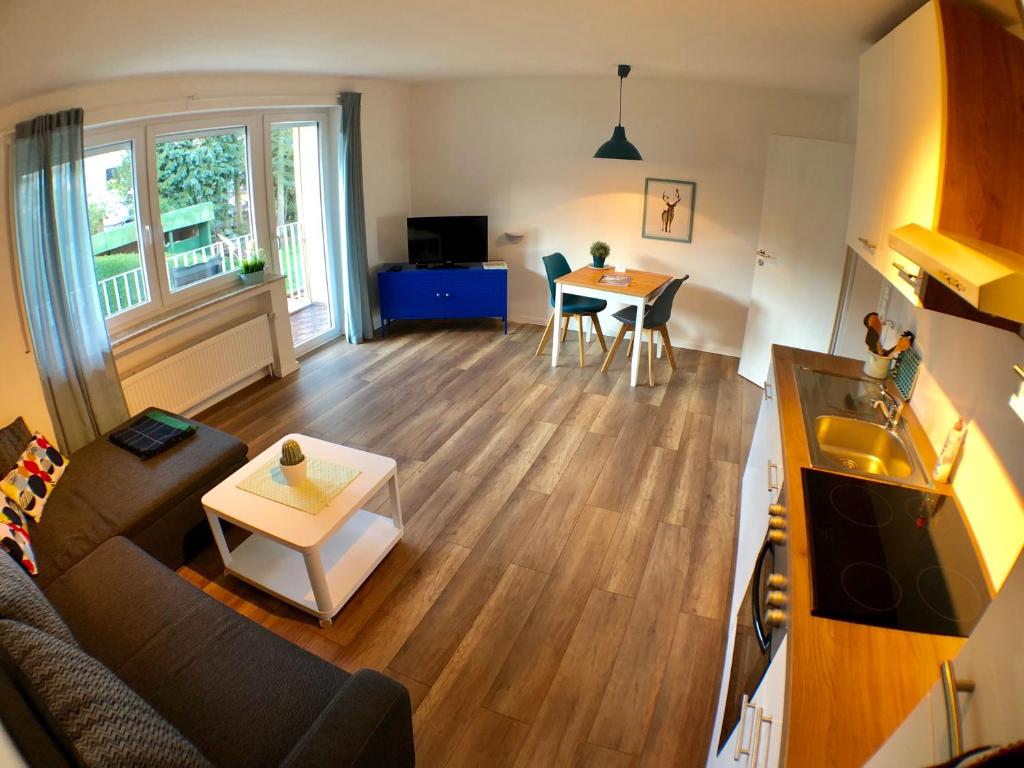 ein Wohnzimmer mit einem Sofa und einem Tisch in der Unterkunft Auszeit-Eifel Appartements in Willwerscheid