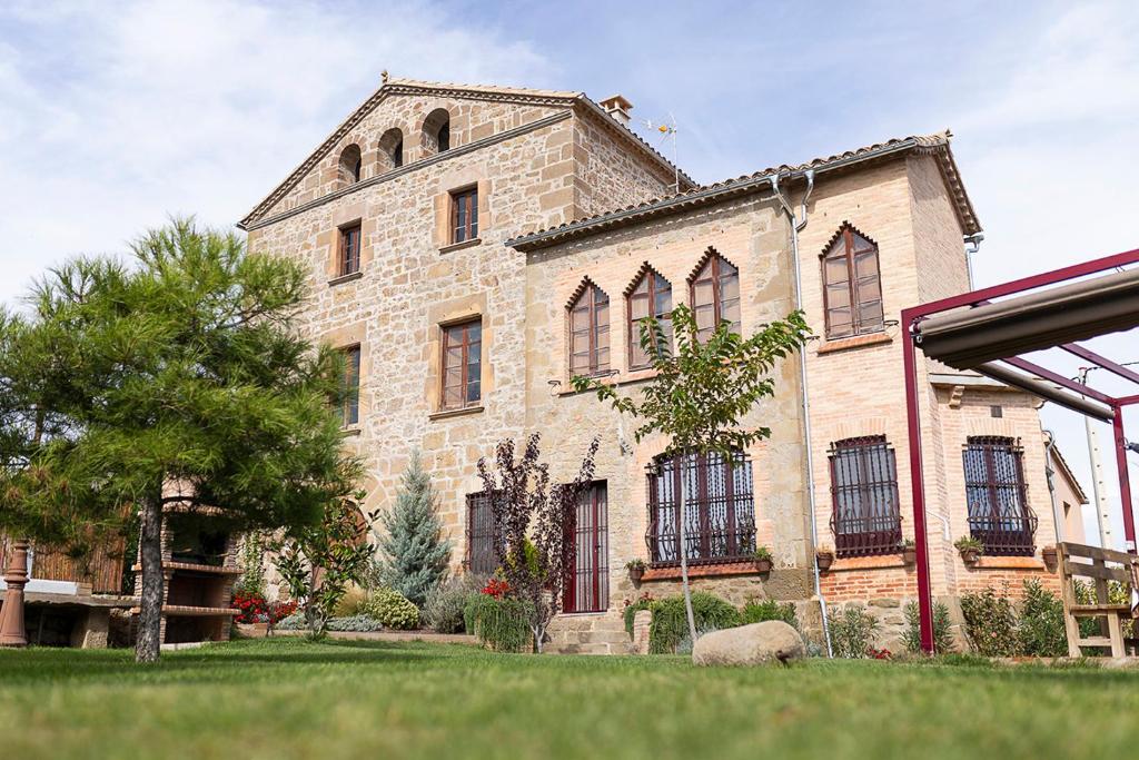 un gran edificio de ladrillo con un árbol delante de él en Torre Caïm, en Solsona