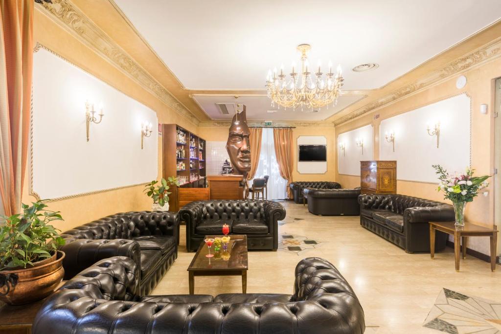 a living room with leather furniture and a chandelier at Hotel Villa Rosa in Rome