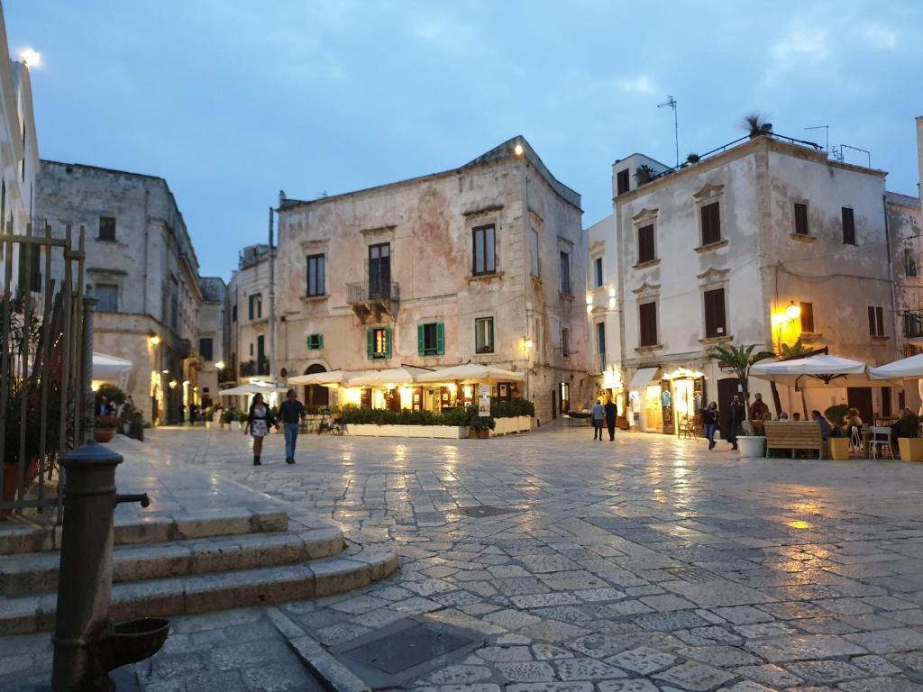 a city street with buildings and people walking around at Lo scrigno dei sogni in Polignano a Mare