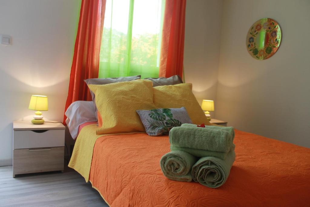 una camera da letto con un letto e asciugamani di Le Bougainvillier a La Plaine des Cafres