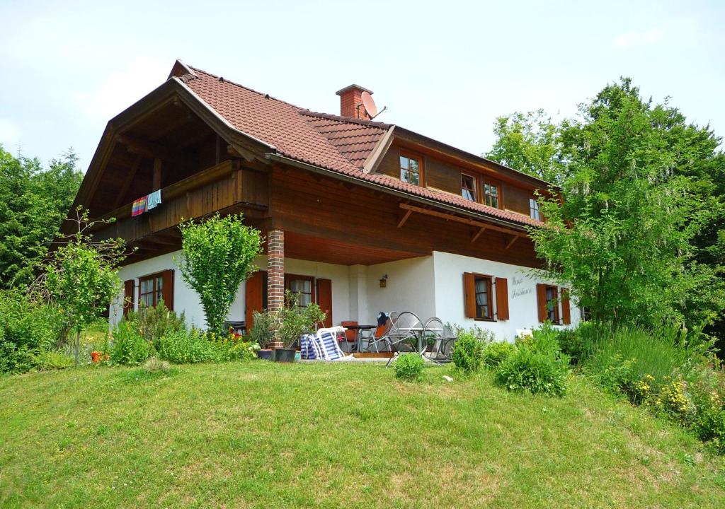 ein Haus auf einem Hügel mit einem Rasenplatz in der Unterkunft Haus Christiane in Pörtschach am Wörthersee