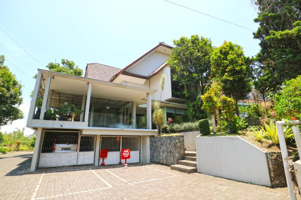 une maison avec un panneau rouge devant elle dans l'établissement RedDoorz near UPI Setiabudi 2, à Bandung