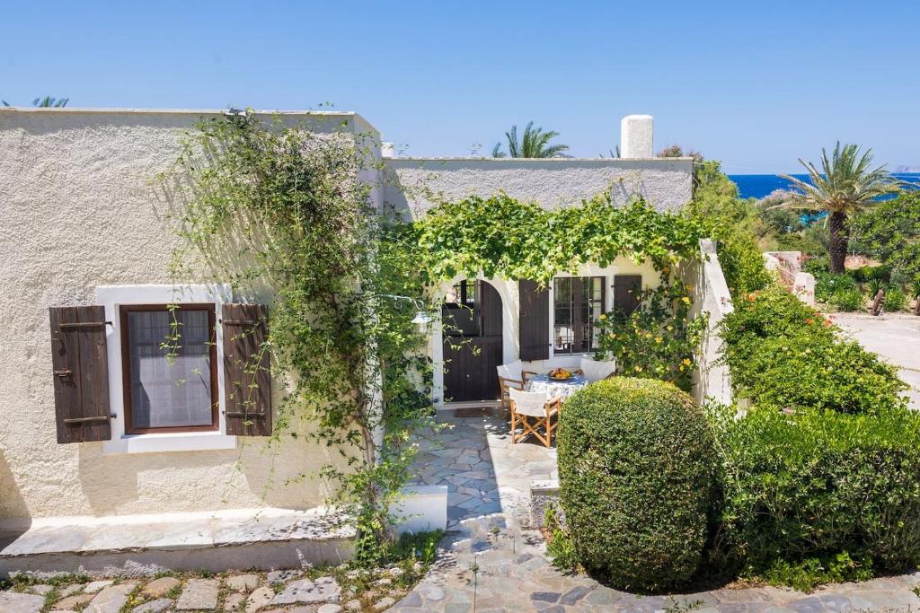 an ivy covered house with a table and a patio at Jasmine house in Sitia