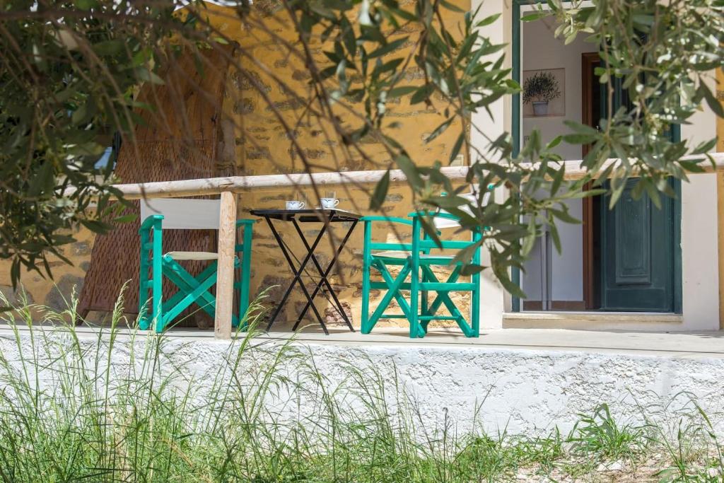 a table and a chair in front of a house at Agrilos Οlive Τree Αpartment in Mirsíni