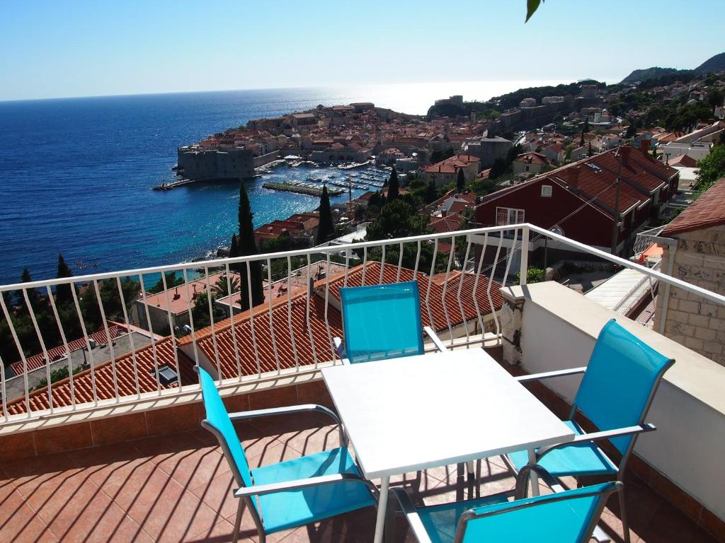 balcón con mesa, sillas y vistas al océano en Apartments Novak en Dubrovnik