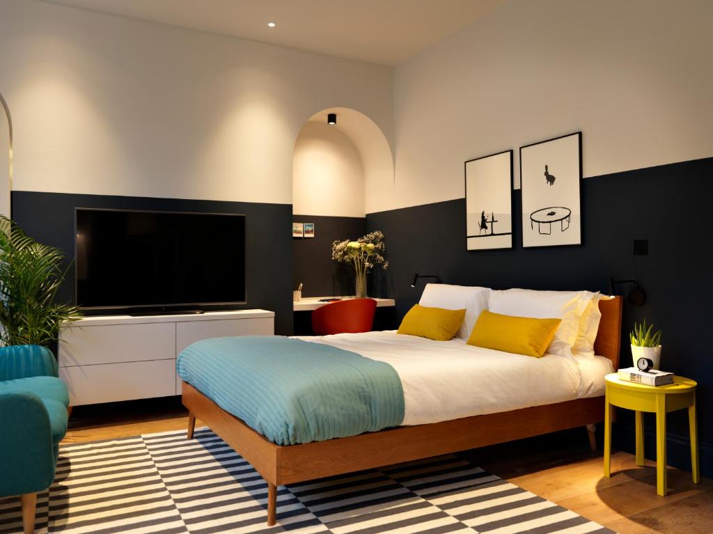 a living room with a large bed and a television at Student Castle - Studio Apartments in Bath