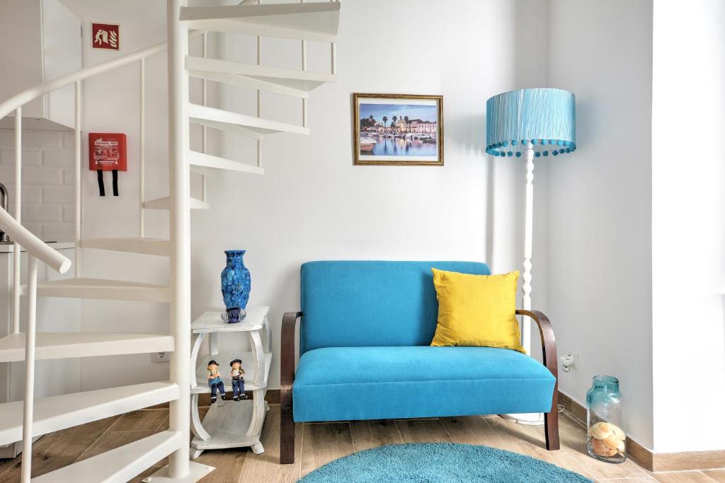 uma cadeira azul numa sala de estar com uma escada em Blue Barqueta Studio em Faro