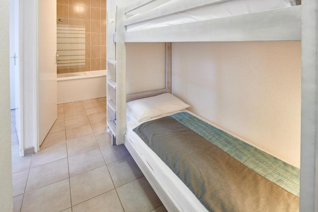 a bedroom with a bunk bed in a room at Résidence Vacances Bleues Les Jardins d'Arvor in Bénodet
