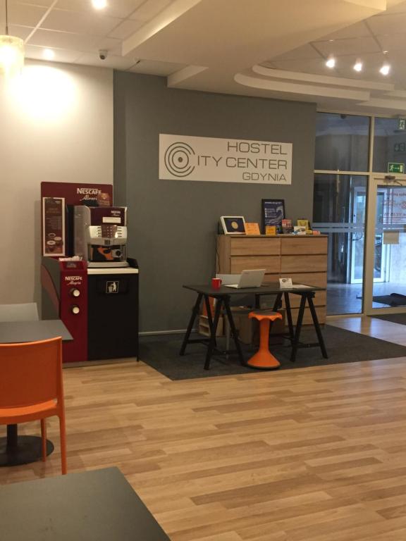 a waiting room with a desk and a table at Hostel City Center Gdynia in Gdynia