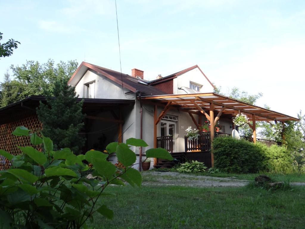 uma casa branca com uma pérgula de madeira em Dom na wzgórzu em Gorlice