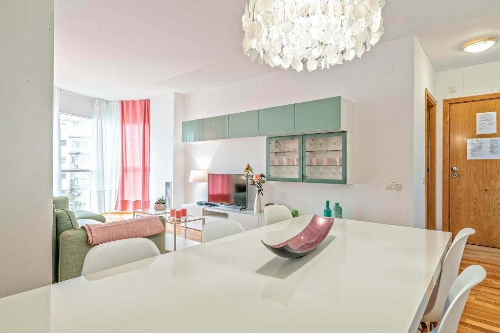 a kitchen and living room with a white table and chairs at Cálido apartamento con piscina en Barcelona in Ripollet