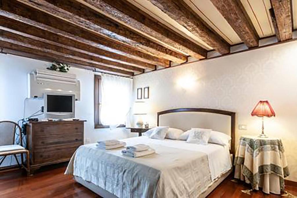 1 dormitorio con 1 cama grande y TV en Venice Luca's house, en Venecia