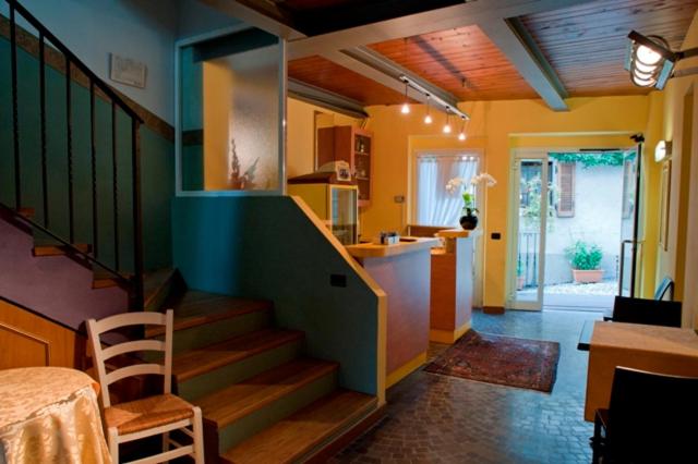 uma sala de estar com uma escada e uma cozinha com uma mesa em Hotel Bettina em Mergozzo